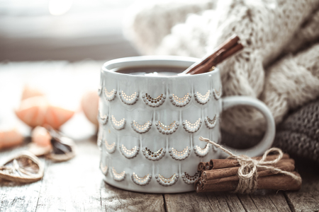 Details of still life in the home interior living room. Beautiful Cup of tea with tangerines and sweaters on wooden background . Cosy autumn-winter conceptの写真素材