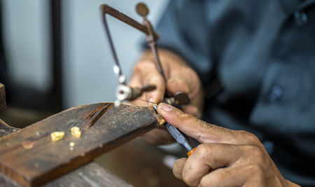 Thai jeweler, handles the jewelry and precious stones in the workshop, the process of jewelry making ,close-upの写真素材