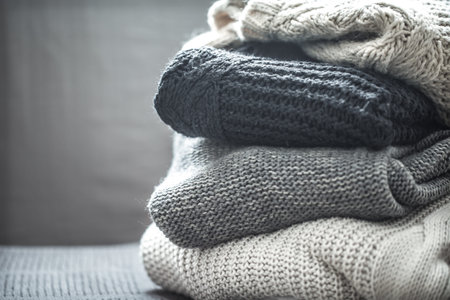 A stack of knitted sweaters ,the concept of warmth and comfort, hobby , background,closeup