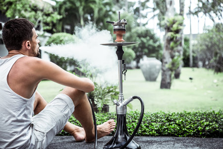 man smoking a hookah on vacation background lifestyle concept