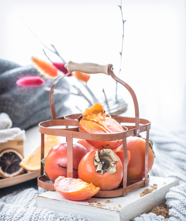 Still life fresh persimmon in a basket on a serving table preparation for breakfast concept of holdingの写真素材