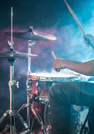 man plays the drum, close-up, flash of light, a beautiful light in the background with copy spaceの写真素材