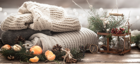 Christmas still life of a live Christmas tree, decorations and festive wreath on a background of knitted clothes and Mandarinの写真素材