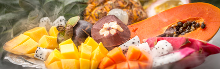 Exotic fruits in smoke from a hookah close-up on a trayの写真素材