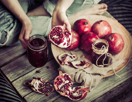 healthy food pomegranate juice detox on a wooden tray girl in hands, the concept of a healthy diet and fruit vitaminsの写真素材