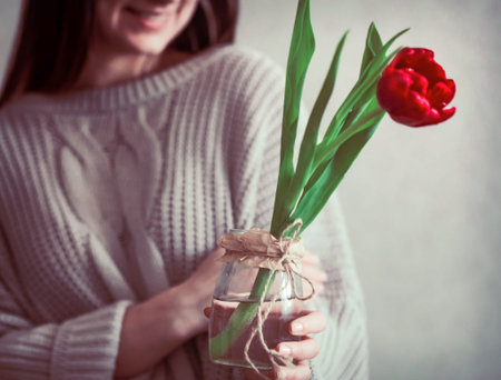 Girl with tulip in hands, concept of spring and female holiday