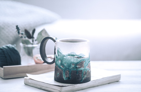book and a cup of tea on a wooden background, the concept of coziness and pastimeの写真素材