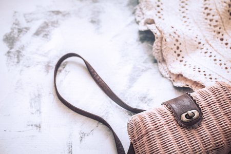 female bag with a straw hat on a light wooden background, a concept of summer styleの写真素材