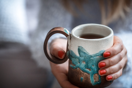girl holding a beautiful cup of tea in hands, concept of hot drinksの写真素材