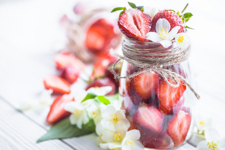 Fresh strawberries in a jar on a light backgroundの写真素材