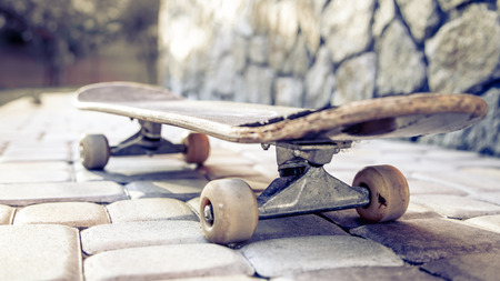 old skateboard close-up, against a background of paving slabs.の写真素材
