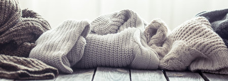Knitted sweater on a wooden background, space for text