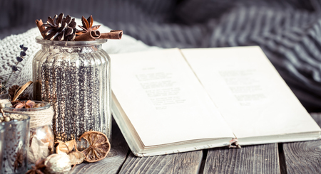 hipster autumn composition with a book in the interior of a living room in vases on a wooden backgroundの写真素材
