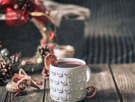 mulled wine in a beautiful cup on a wooden background, with christmas decor, concept of holidays and hot seasonal drinksの写真素材