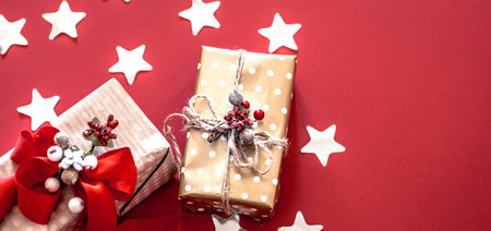 Christmas concept, two gift boxes with decor on red background, space for text
