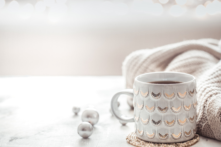 cozy winter composition with a cup and sweater on a light festive backgroundの写真素材