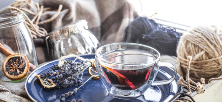 Still life with decor and a cup of tea on a plate by the window, the concept of cozinessの写真素材
