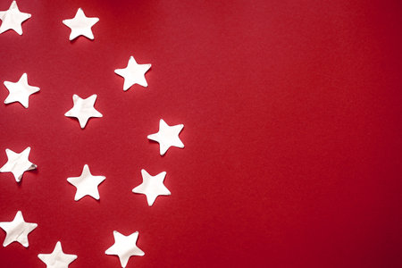 shiny confetti stars in silver colour on a red background , place for text