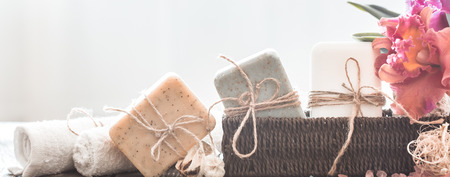Spa composition of soap in a wicker stand with a tropical orchid on a light background, body care conceptの写真素材