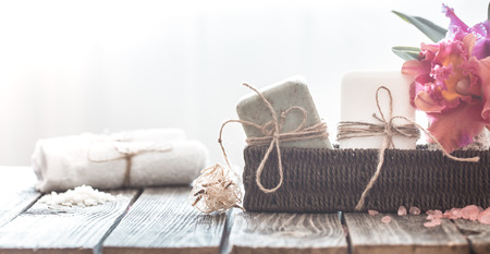 Spa composition of soap in a wicker stand with a tropical orchid on a light background, body care conceptの写真素材