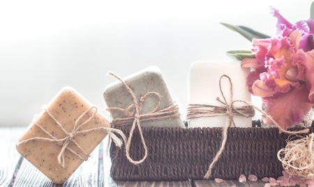Spa composition of soap in a wicker stand with a tropical orchid on a light background, body care conceptの写真素材