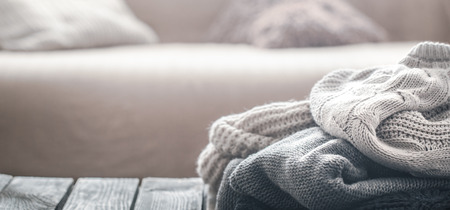 Background with knitted sweaters on a wooden background, the concept of warm clothesの写真素材