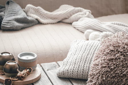 still life from home interior on a wooden background with a candle and pillows, home comfort conceptの写真素材