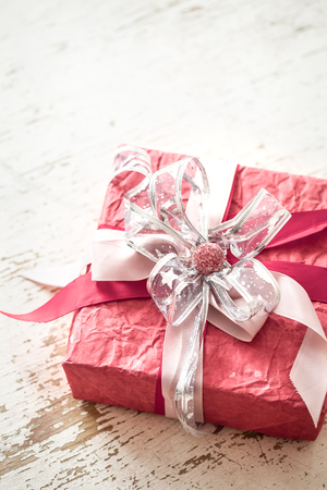 Valentine's day and mother's day concept, red gift box with bow and roses on light wooden backgroundの写真素材