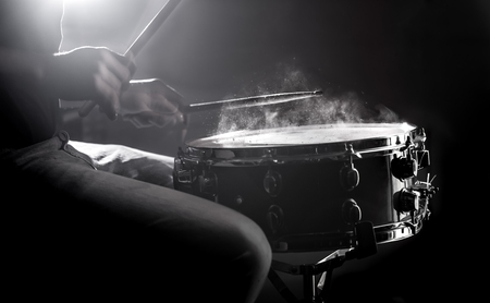 man playing the snare drum on a beautiful colored background, the concept of musical instrumentsの写真素材