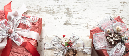Festive beautiful gift boxes with a bow on a light wooden background.の写真素材