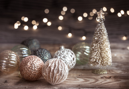 Christmas or New Year festive background, vintage toys on the Christmas tree on a wooden background with a garland with lightsの写真素材