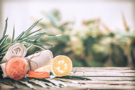 Spa handmade soap and a towel, the composition of the tropical leaves wooden background with space for text, concept of Spa and relaxation for the bodyの写真素材