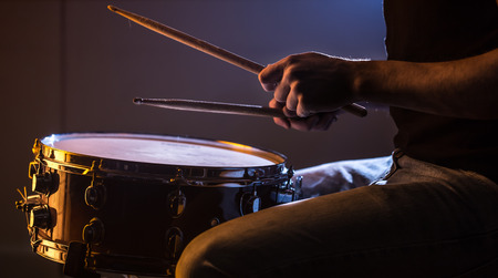 man playing the snare drum on a beautiful colored background, the concept of musical instrumentsの写真素材