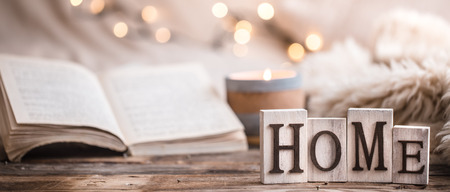 Composition homely festive atmosphere in the interior with home decor items and wooden letters with the words home, the concept of comfort and cozinessの写真素材
