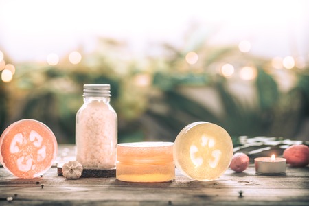 Spa handmade soap with sea salt, composition on tropical leaves with a candle, wooden background with a place for text, Spa concept and relaxation for the bodyの写真素材