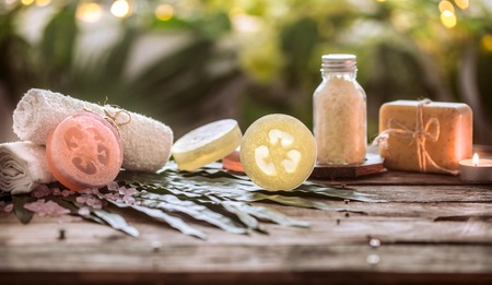 Spa handmade soap with white towels and sea salt, the composition of the tropical leaves with a candle, wooden background with space for text, concept of Spa and relaxation for the bodyの写真素材