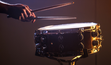 man playing the snare drum on a beautiful colored background, the concept of musical instrumentsの写真素材