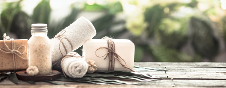 Spa handmade soap with white towels and sea salt, composition on tropical leaves, wooden background with space for text, Spa concept and relaxation for the bodyの写真素材