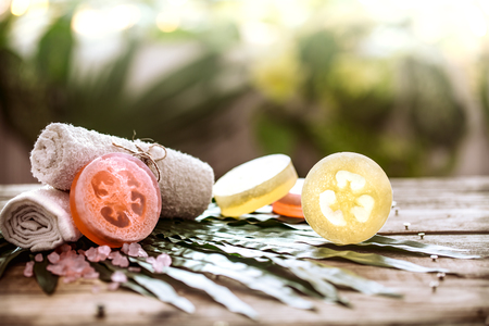 Spa handmade soap and a towel, the composition of the tropical leaves wooden background with space for text, concept of Spa and relaxation for the bodyの写真素材