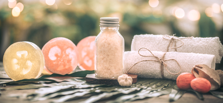 Spa handmade soap with white towels and sea salt, composition on tropical leaves, wooden background with space for text, Spa concept and relaxation for the bodyの写真素材