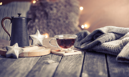 home comfort, details of the festive interior on a wooden table and lights in the backgroundの写真素材