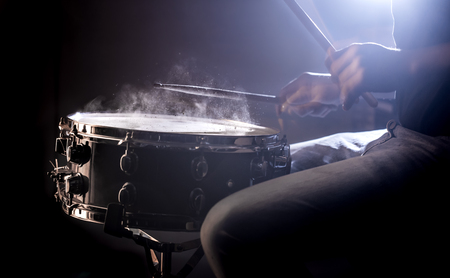 man playing the snare drum on a beautiful colored background, the concept of musical instrumentsの写真素材