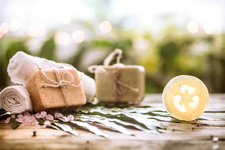 Spa handmade soap and a towel, the composition of the tropical leaves wooden background with space for text, concept of Spa and relaxation for the bodyの写真素材