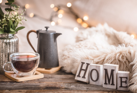 Composition homely festive atmosphere in the interior with home decor items and wooden letters with the words home, the concept of comfort and cozinessの写真素材