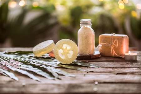 Spa handmade soap with sea salt, composition on tropical leaves with a candle, wooden background with a place for text, Spa concept and relaxation for the bodyの写真素材