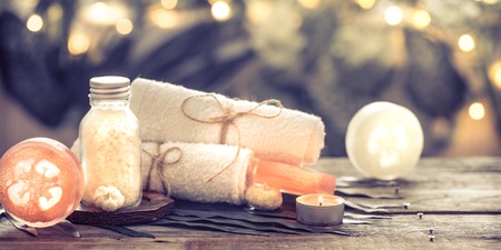 Spa handmade soap with white towels and sea salt, the composition of the tropical leaves with a candle, wooden background with space for text, concept of Spa and relaxation for the bodyの写真素材