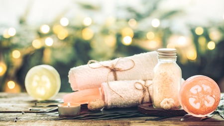 Spa handmade soap with white towels and sea salt, the composition of the tropical leaves with a candle, wooden background with space for text, concept of Spa and relaxation for the bodyの写真素材
