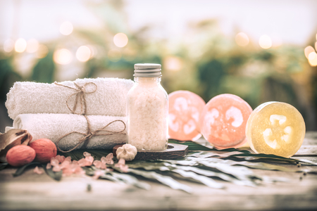 Spa handmade soap with white towels and sea salt, composition on tropical leaves, wooden background with space for text, Spa concept and relaxation for the bodyの写真素材