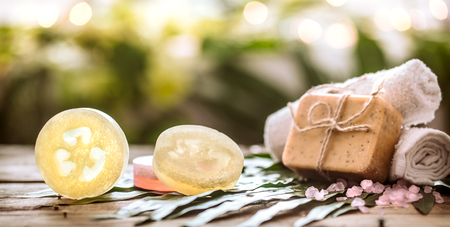 Spa handmade soap and a towel, the composition of the tropical leaves wooden background with space for text, concept of Spa and relaxation for the bodyの写真素材