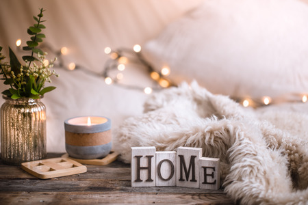 Composition homely festive atmosphere in the interior with home decor items and wooden letters with the words home, the concept of comfort and cozinessの写真素材
